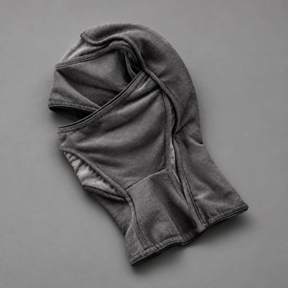 Grey Deamon facemask laid flat, showing the eye opening and curved fabric panels
