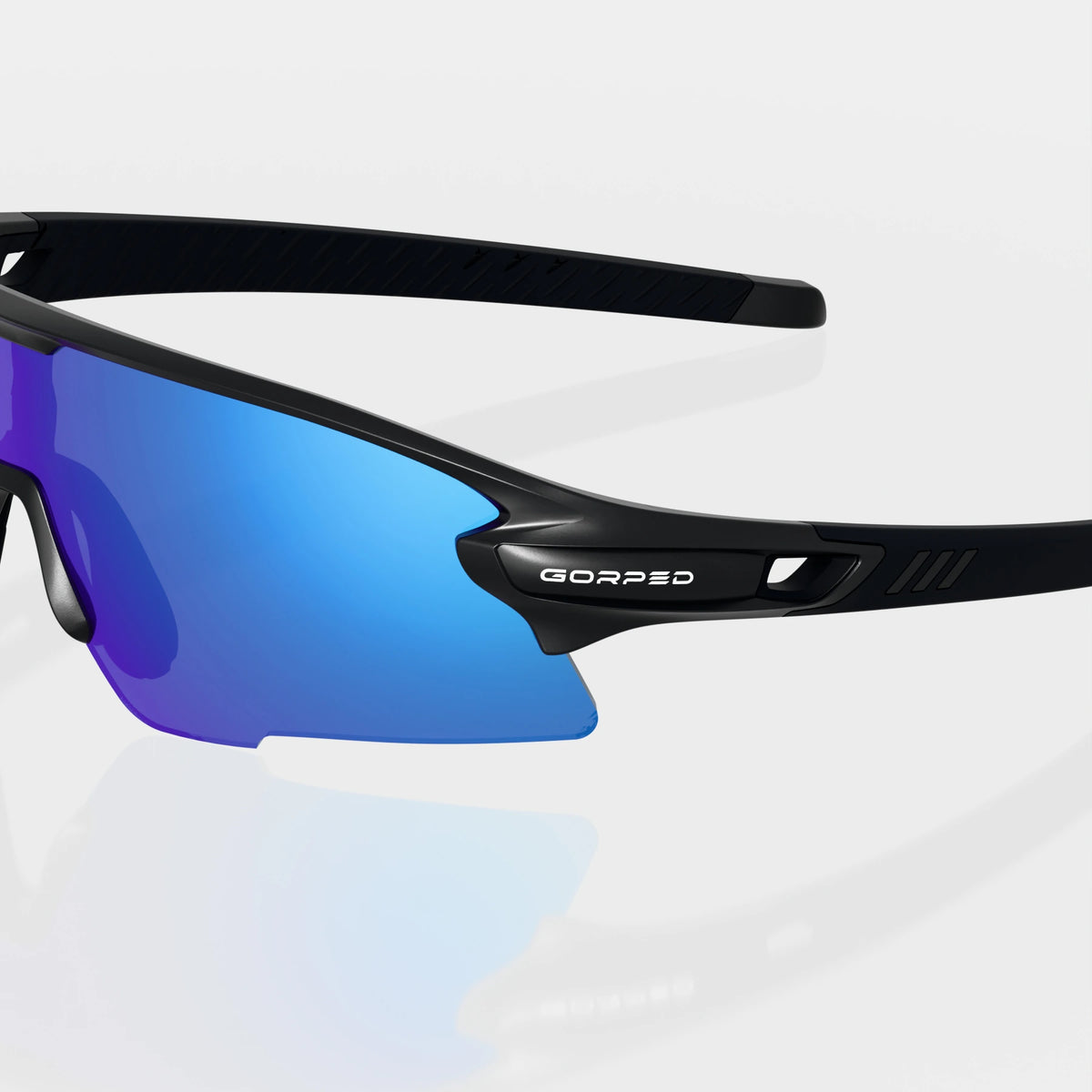 Strider Glacier sunglasses with a close view of the GORPED logo and temple on a pale studio background